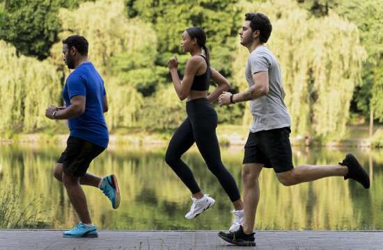 Personas corriendo por una caminería junto a un río
