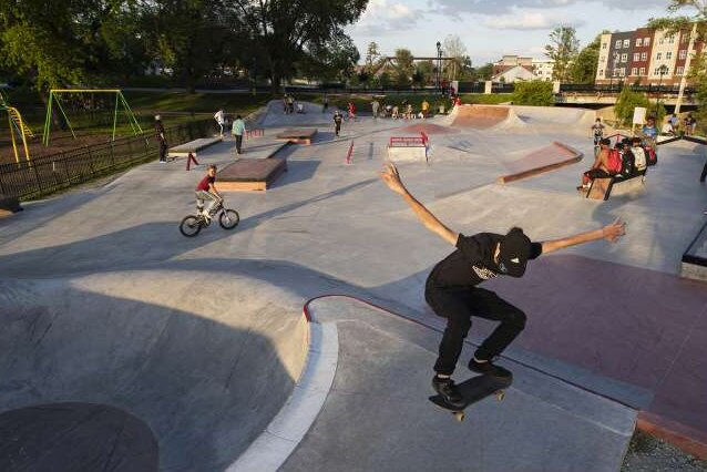 Joven saltando con su patineta en un skatepark de concreto